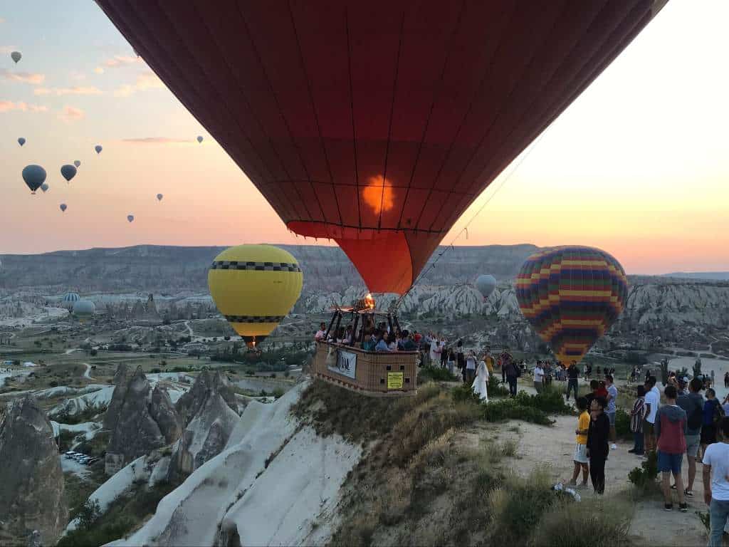 A hot air balloon floating near passersby.